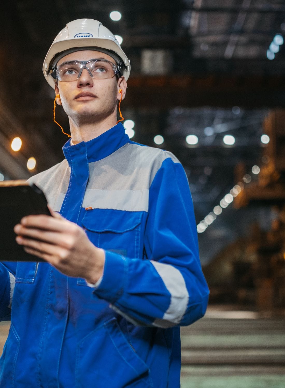 Process engineer checking live batch data on the floor of a chemical plant