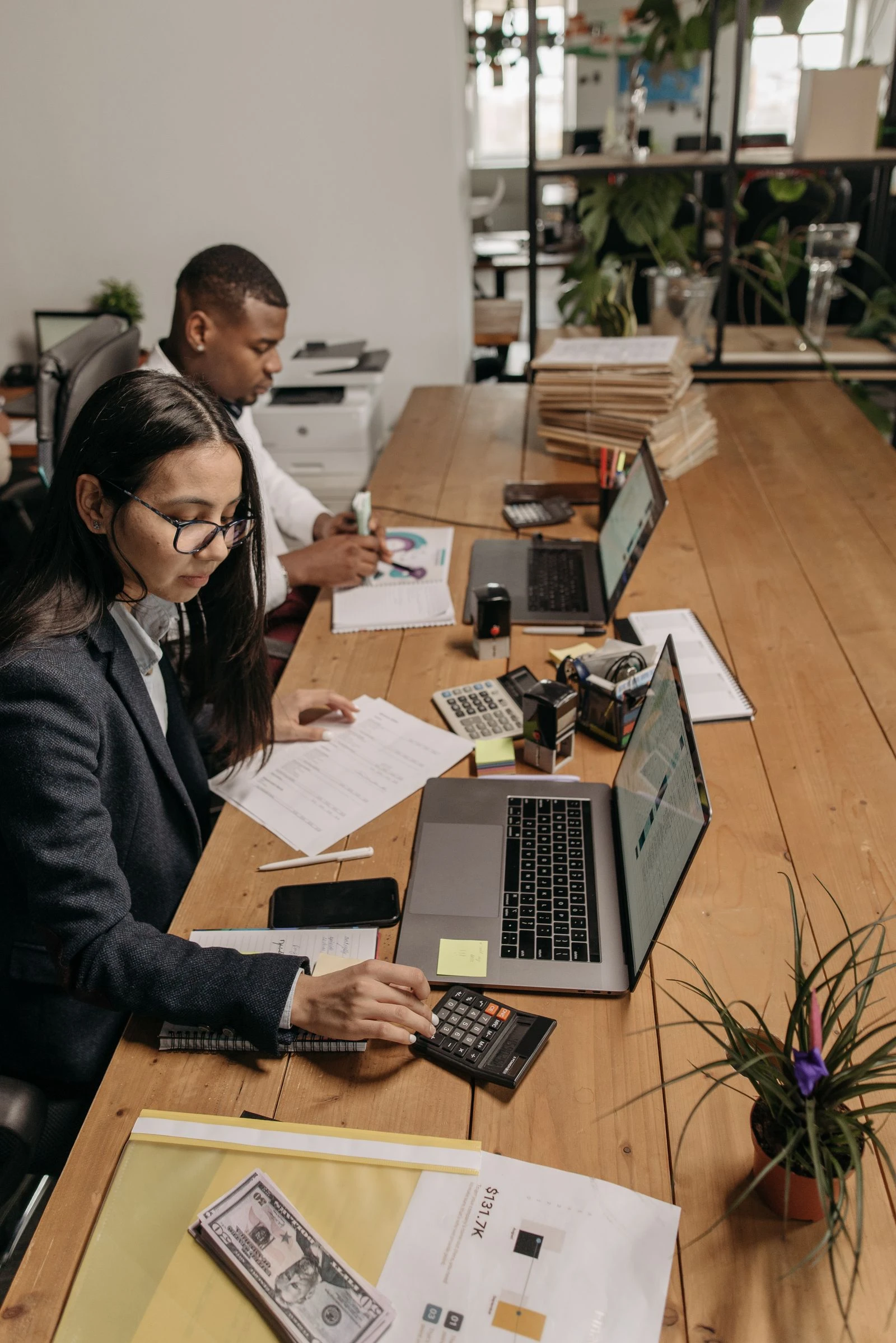 Two accountants setting up software and tools at a shared table
