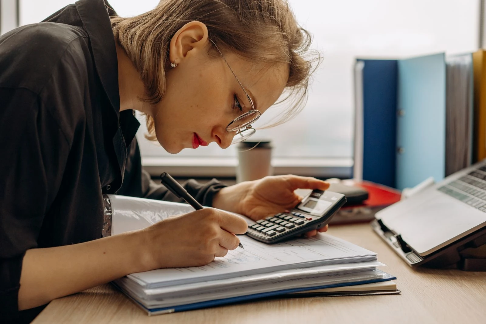 Bookkeeper focused on calculations with documents at a desk