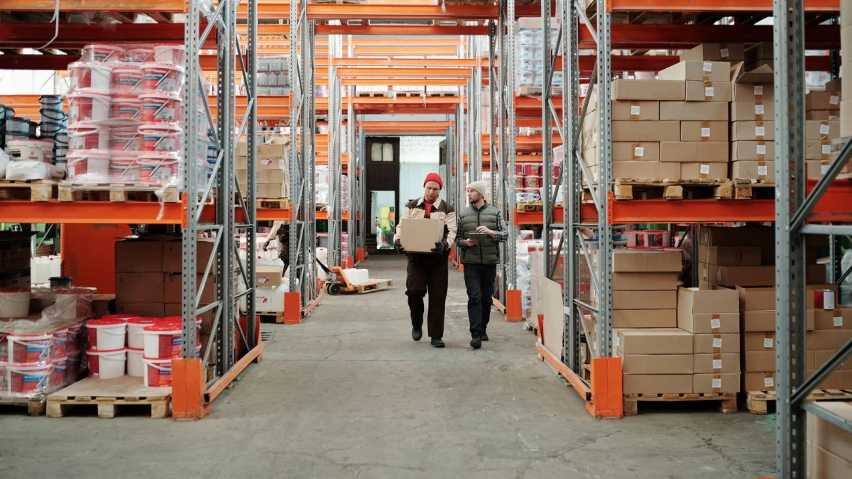 Warehouse team handling packages among stocked shelves