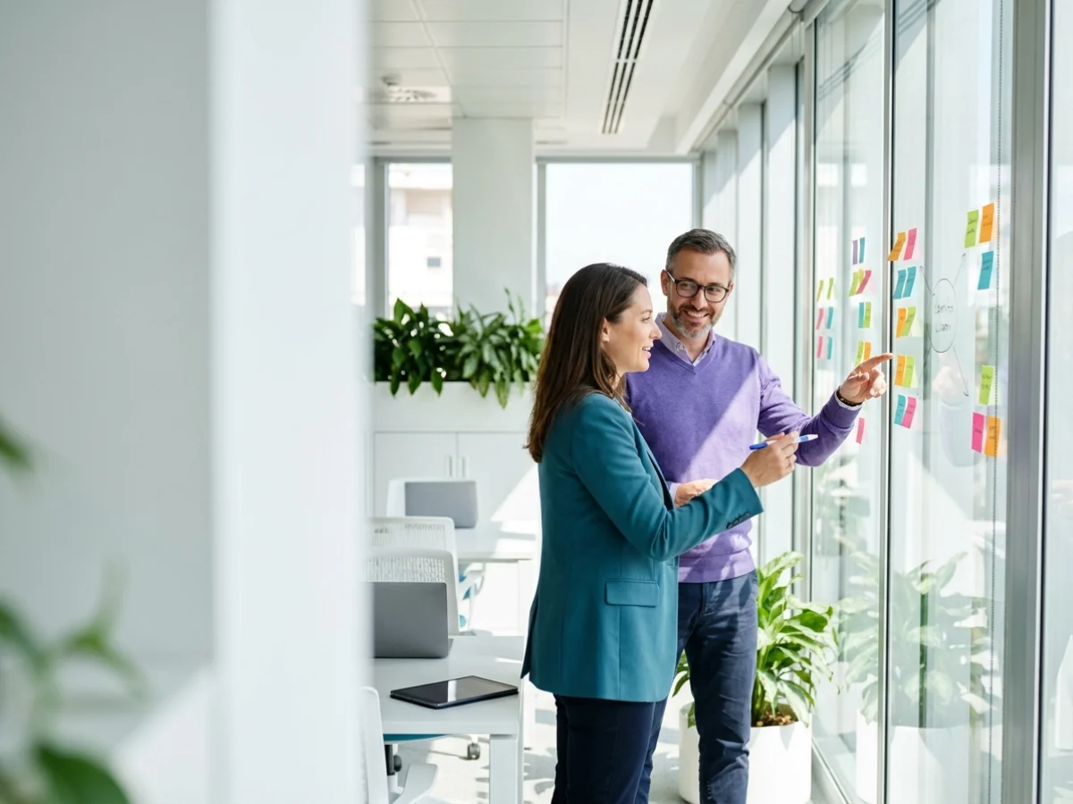 ERP consultant sketching a process flowchart on a whiteboard while client team leads discuss it