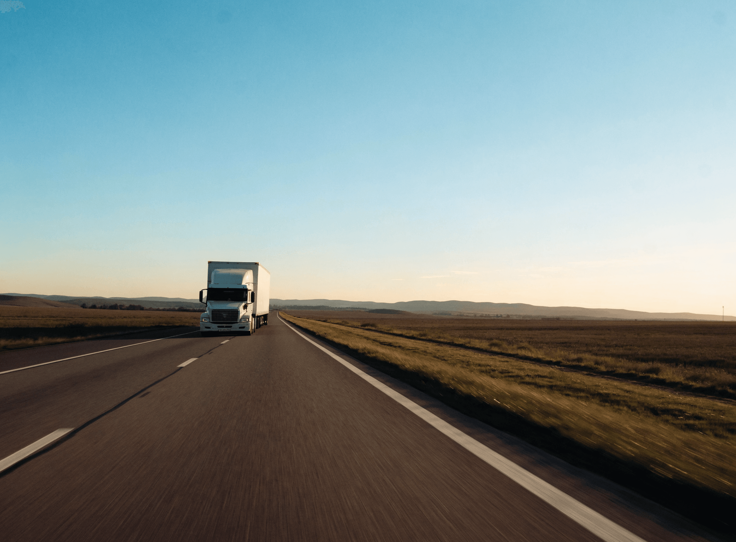 Tractor and dry van trailer travelling on an interstate at golden hour