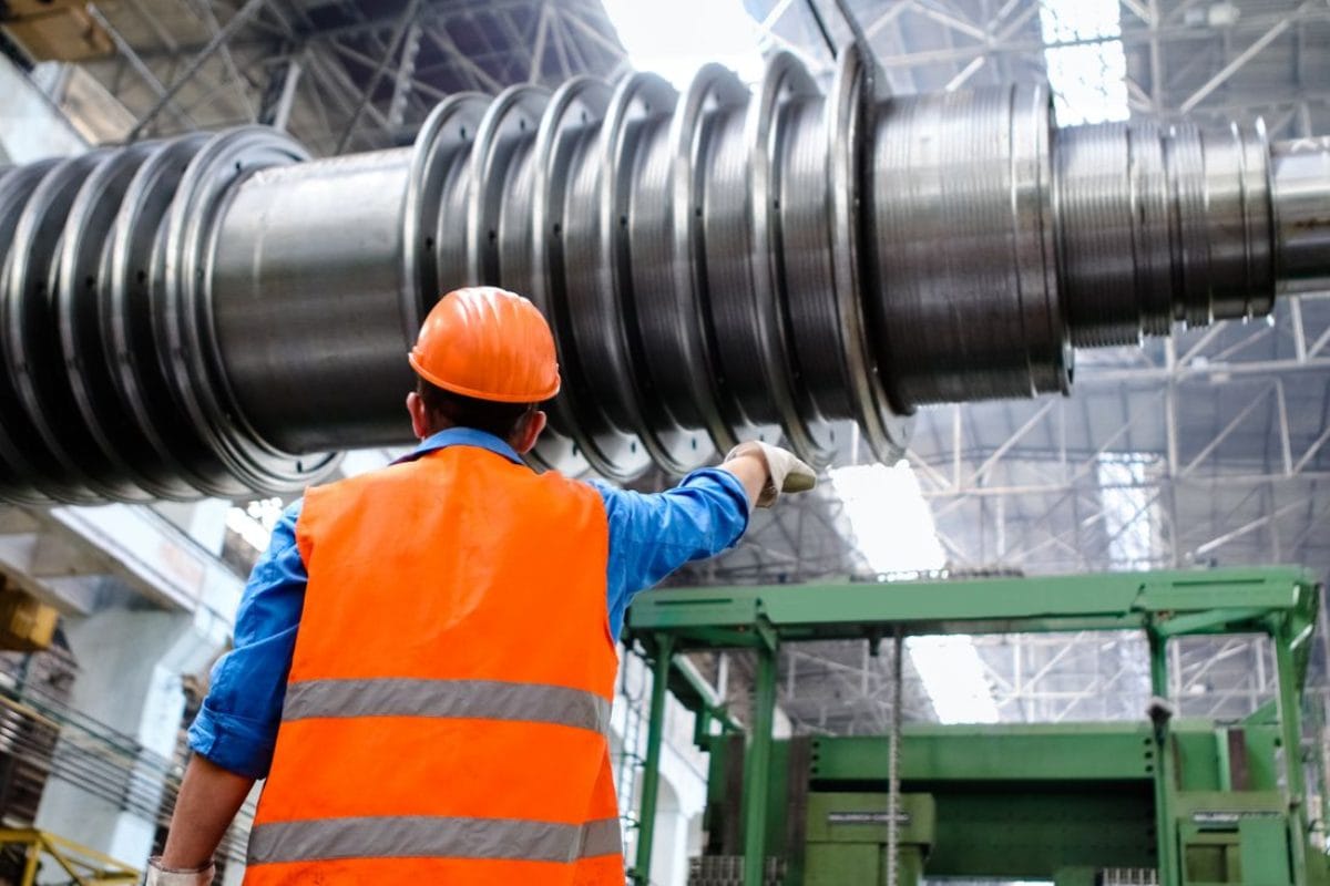 Technician inspecting a machined drive shaft during planned maintenance