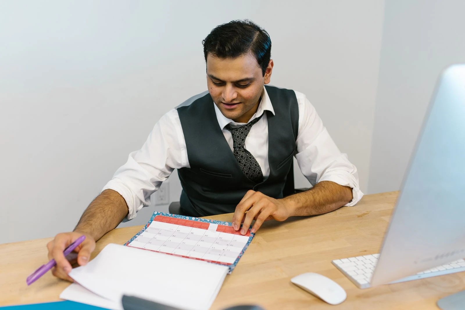 Man reviewing a schedule calendar at his desk
